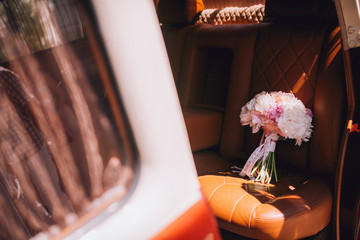 Big bouquet of colorful flower from beautiful fresh pink and white peonies in luxury car. Valentines day romantic