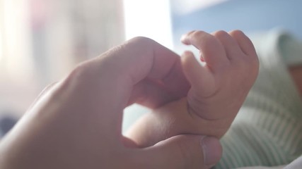 Close up of a newborn baby hand holding the finger of a parent