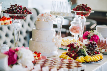 Delicious wedding reception candy bar dessert table. For a party. Ombre cake, cupcakes, sweetness and flowers