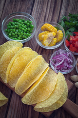 Mexican corn tortilla tacos with vegetables on wooden background