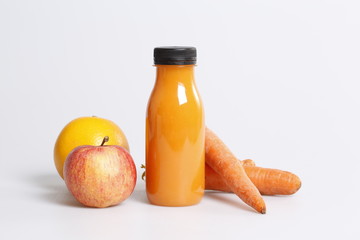 Orange juice bottle with apples and carrots