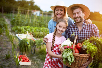 Satisfied farmers family with organic vegetables - obrazy, fototapety, plakaty