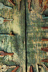 The keys on old wooden background from above with text space