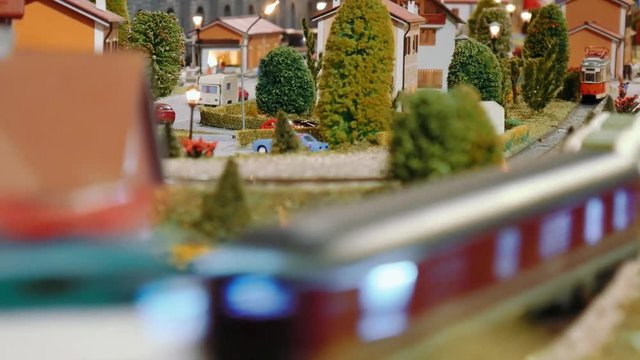 Model trains transit and a tram departs on a diorama
