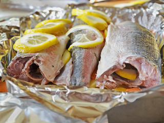 Marinating fresh fish with herbs before baking it on a bed of vegetables