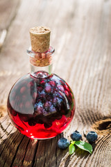 Homemade liqueur in a bottle with alcohol and blueberries