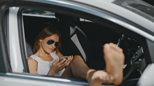 young woman in sunglasses resting in the car and Sending Messages