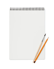 Naklejka premium Top view of blank sketchbook with pencil and brush