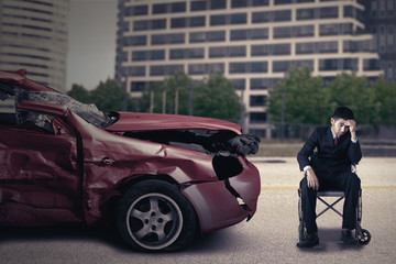 Disabled person with wheelchair and damaged car