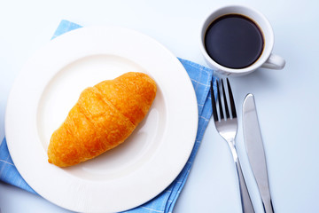 Top view of breakfast with croissants and a cup of black coffee.