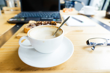 Laptop and latte coffee on wooden table