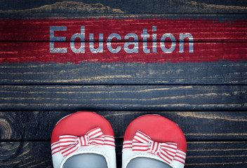 Education message and kid shoes on floor