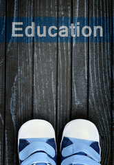Education message and kid shoes on floor
