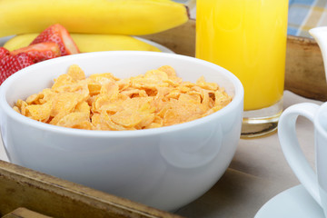 Breakfast tray with orange juice, cereals and fruits.