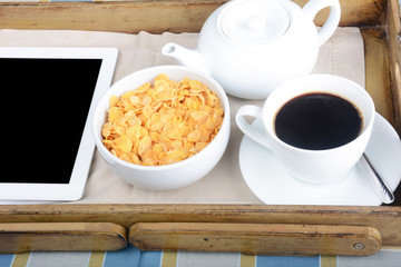 Breakfast tray with coffee, cereals and tablet.