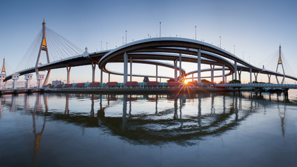 Sunset over two suspension bridged with reflection and clear blue sky background
