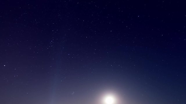 moon and stars on black night sky time lapse