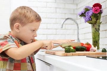 funny child boy cooking in the kitchen. Healthy food at home