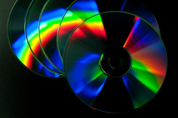 CD and DVD disk on black background.