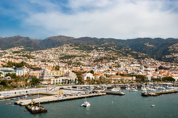 Fototapeta na wymiar Aerial view Portuguese Port in Funchal Madeira Island in Atlantic Ocean. Tranquil view of Funchal surrounded by blue ocean under partly cloudy sky in Madeira Portugal