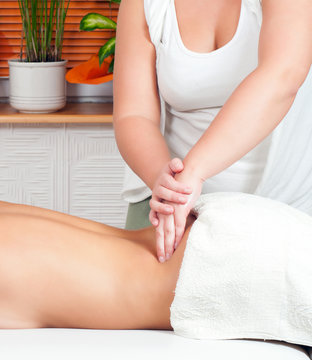 Young massage therapist giving a massage in beauty spa