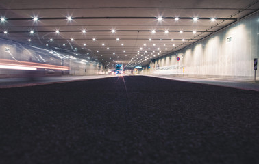 Fast cars in a modern tunnel by night