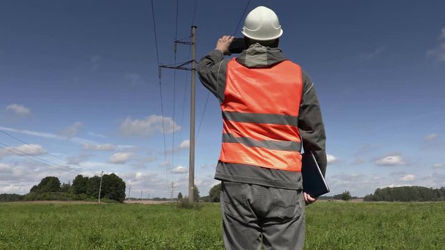 Electrician take pictures under high-voltage lines
