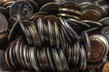 Coin one ruble against the background of a hill of the small coins lying in a disorder