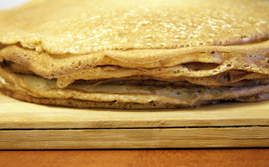 Stack of homemade pancakes on wood cooking board