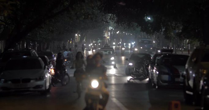 Lots of motorbikes and few cars driving on the motorway in night Hanoi, Vietnam. Faces unidentified and logos washed out