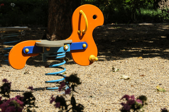 Orange horse teeter on the blue spring in sunlight