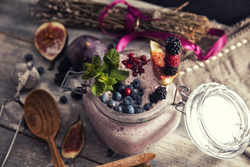 Obraz na płótnie Canvas bright detox smoothie with berries on wooden background bowl