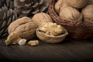 Walnut kernels and whole walnuts on rustic old wooden table