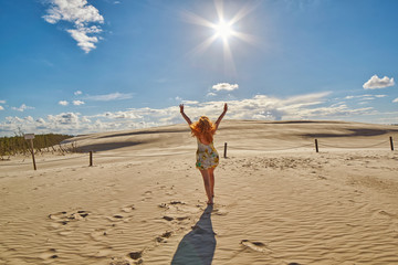 Happy Woman against Sand Dunes in Leba, Poland - obrazy, fototapety, plakaty