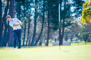 Obraz premium golfer playing a chip shot onto the green