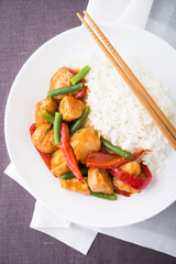 Spicy chicken with vegetables ( green beans and red pepper) and rice top view. Oriental food.
