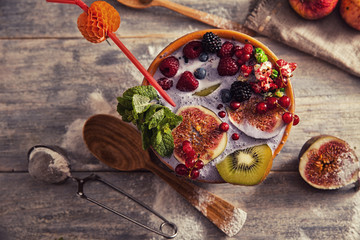 bright detox smoothie with berries on wooden background bowl