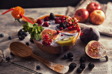 bright detox smoothie with berries on wooden background bowl
