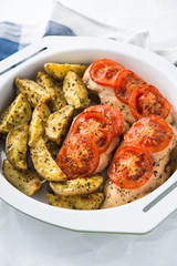 Dry basil parmesan fries and tomato chicken oven baked close up.
