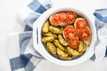 Dry basil parmesan fries and tomato chicken oven baked top view on white background.