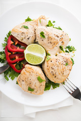 Chicken breasts with parsley, pepper and citrus on white wood background top view. Healthy food.