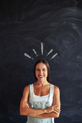 Smiling woman with crossed hands against chalk drawing of exclam