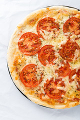 Pizza with tomato, cheese and dry basil on white background top view. Italian cuisine.