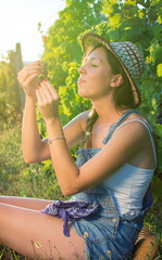 Happy woman eating grapes in vineyard