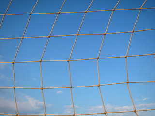 Old net for beach volleyball on empty sea coast
