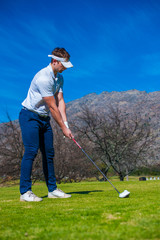 Fototapeta premium view of a golfer teeing off from a golf tee