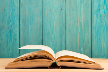 Open book on the desk over wooden background