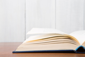 Open book on the desk over wooden background