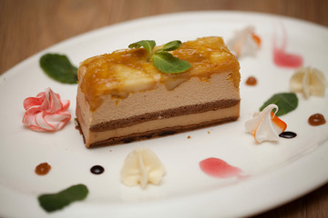 Tasty piece of chocolate cake on wooden table background