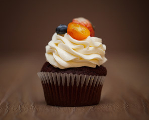 Homemade Chocolate Cupcake with chocolate frosting on wooden table